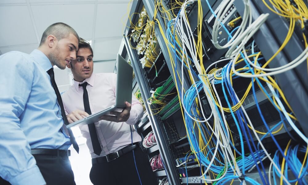 two business people examining a server and assessing IT network