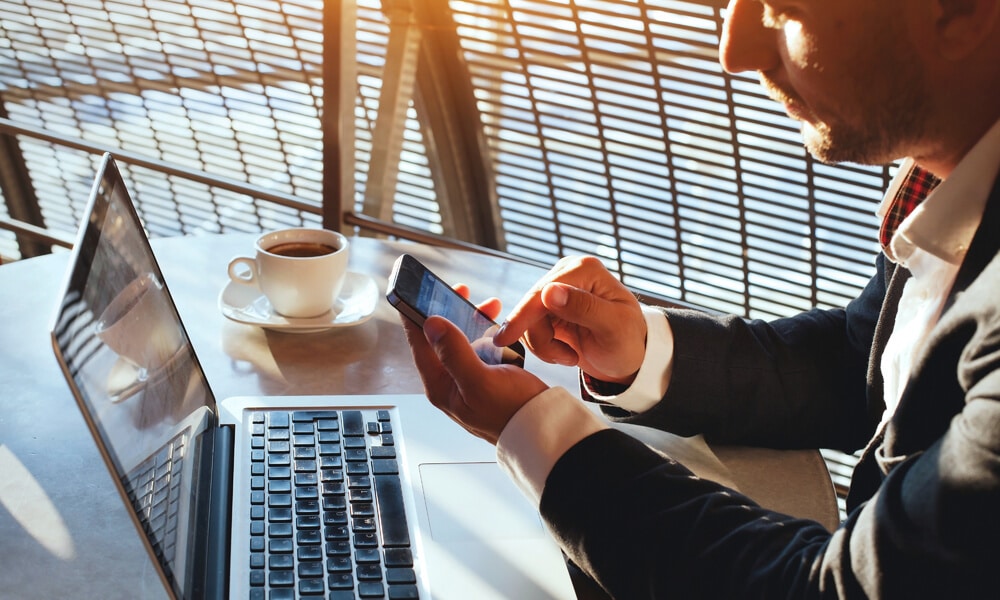 man in office using wifi on computer and phone