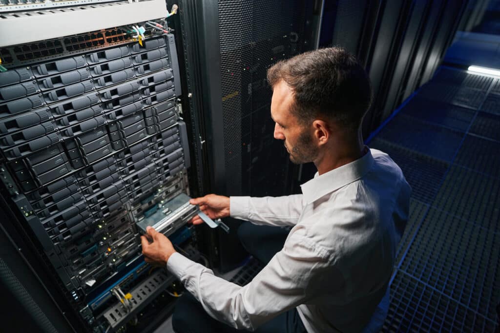 professional IT technician working in server room, ensuring systems meeting DFARS compliance requirements