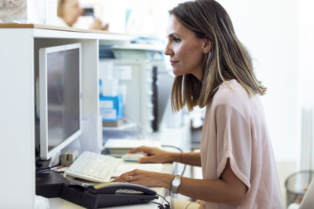 businesswoman working at desk, enjoying fully managed it services