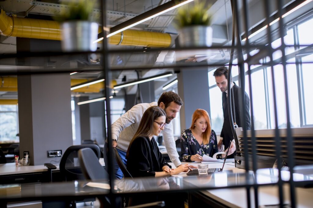 employees in office working on computer doing research