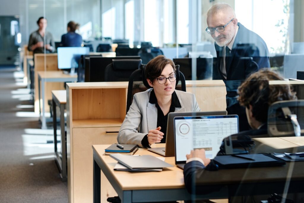 colleagues in office discussing information on computers