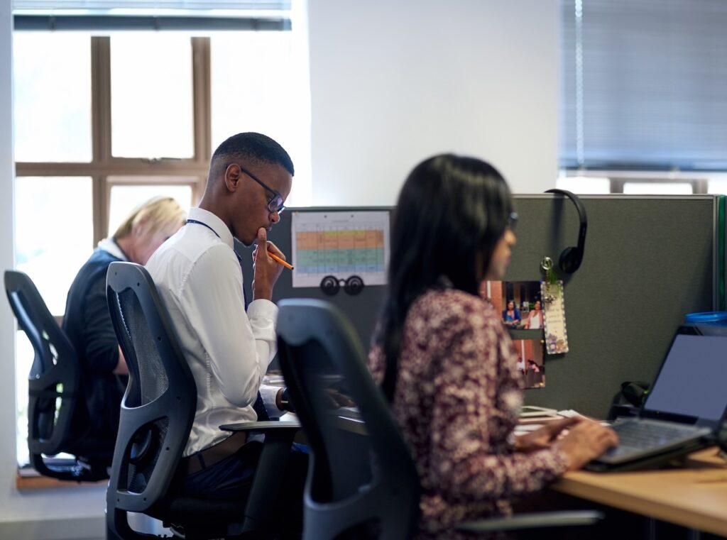 coworkers in office using public cloud managed services to complete collaborative tasks